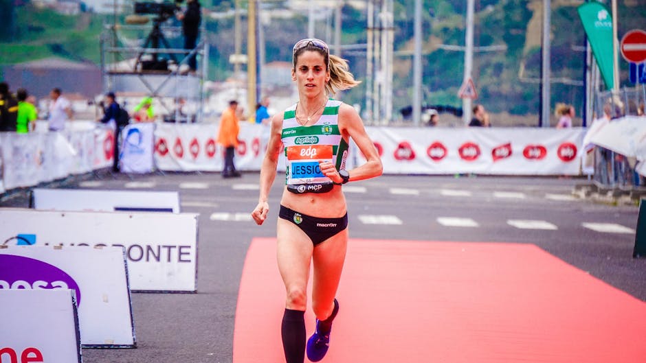 Focused female athlete crossing the finish line during an outdoor marathon race
