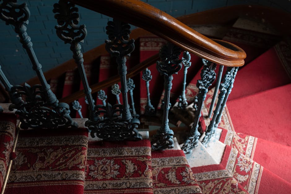 Close-up of ornate vintage staircase with red carpet
